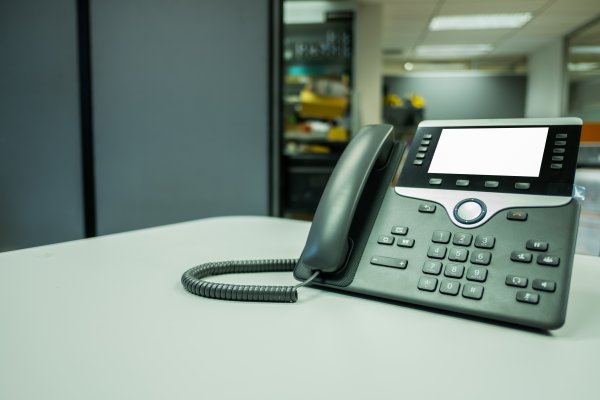 benefits phonepower voip service voip phone in office on desk servers in the background